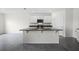 Modern kitchen features a central island with bar seating, modern appliances, and a tile floor at 4497 Yaupon Holly Way, Lakeland, FL 33811