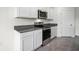 Modern kitchen featuring stainless steel appliances, granite countertops, and white cabinetry for ample storage at 4497 Yaupon Holly Way, Lakeland, FL 33811