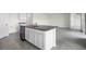 Kitchen island features a stainless steel sink, granite countertops, and white cabinets, perfect for entertaining at 4497 Yaupon Holly Way, Lakeland, FL 33811