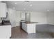 Open concept kitchen flows into a spacious living area, complete with a granite countertop island and white cabinets at 4497 Yaupon Holly Way, Lakeland, FL 33811
