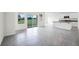 Bright, open-concept living area with tile floors and a modern kitchen featuring a center island and stainless appliances at 4497 Yaupon Holly Way, Lakeland, FL 33811