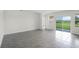 Bright, open-concept living area with tiled floor and sliding glass door to patio at 4497 Yaupon Holly Way, Lakeland, FL 33811