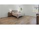 Comfortable bedroom with wood-look tile flooring, natural light, and neutral decor at 4779 Cragmere Loop, Clermont, FL 34711