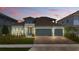 Charming single Gathering home showcasing a three car garage, elegant stonework, and manicured lawn at 4779 Cragmere Loop, Clermont, FL 34711