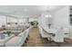 Open-concept living and dining area with a modern kitchen in the background and beautiful floors at 4779 Cragmere Loop, Clermont, FL 34711