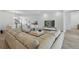 Bright living room with a tan sectional, modern decor, wood-look flooring, and a dining area in the background at 4779 Cragmere Loop, Clermont, FL 34711
