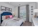 Bright bedroom showcasing a plush blue headboard, decorative pillows, artwork, and window at 4928 Bluebell Ct, Lake Hamilton, FL 33851