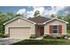 Single Gathering home with stone accents, tan siding, a 2 car garage, brown roof, and manicured landscaping at 4928 Bluebell Ct, Lake Hamilton, FL 33851