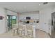 Bright, modern kitchen featuring stainless steel appliances, white cabinetry, and a center island with bar stool seating at 4928 Bluebell Ct, Lake Hamilton, FL 33851