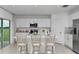 Bright eat-in kitchen with white cabinets, stainless steel appliances, and bar seating at 4928 Bluebell Ct, Lake Hamilton, FL 33851