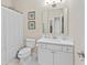 Neutral bathroom with a white vanity, framed mirror, and a shower/tub combination with a white curtain at 5108 Creekside Park Ave, Orlando, FL 32811