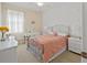 Cozy bedroom with a decorative metal bed frame, desk, and a window that offers natural light at 5108 Creekside Park Ave, Orlando, FL 32811