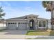 Charming single-story home featuring a stone-accented entrance, gray stucco, and a well-manicured lawn at 5108 Creekside Park Ave, Orlando, FL 32811