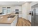 Bright kitchen showcasing white cabinets, stainless steel appliances, and a spacious island with seating at 5108 Creekside Park Ave, Orlando, FL 32811