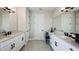 Bright bathroom boasts double sinks, white cabinets with black hardware, and sleek tile flooring for a modern feel at 536 Moon Shell Cir, New Smyrna Beach, FL 32168