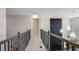 Upstairs hallway with decorative railing, carpeted floor, and pendant lighting at 536 Moon Shell Cir, New Smyrna Beach, FL 32168