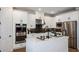 Modern kitchen features stainless appliances, white cabinets, a large island, and designer fixtures at 536 Moon Shell Cir, New Smyrna Beach, FL 32168