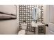 Stylish powder room with decorative wallpaper, pedestal sink, and modern accents at 536 Moon Shell Cir, New Smyrna Beach, FL 32168