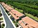 Aerial view showcasing residential buildings with terra cotta roofs along a lush landscape at 5510 Siracusa Ln, Sanford, FL 32771