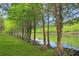 A stunning row of lush trees lining the water offers a peaceful and private setting at 5510 Siracusa Ln, Sanford, FL 32771