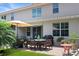 Backyard patio with a dining set, grill, red brick pavers, and lush landscaping at 5510 Siracusa Ln, Sanford, FL 32771