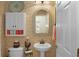 Charming half bath featuring stylish wallpaper, pedestal sink, mirror, and cabinet storage at 5510 Siracusa Ln, Sanford, FL 32771