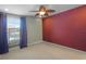 Empty bedroom with a ceiling fan, maroon accent wall, neutral walls, and a large window at 5510 Siracusa Ln, Sanford, FL 32771