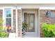 Elegant entryway featuring a decorative glass door, stone accents, and blooming plants at 5510 Siracusa Ln, Sanford, FL 32771