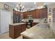 Modern kitchen featuring dark wood cabinets, granite countertops, and stainless steel appliances at 5510 Siracusa Ln, Sanford, FL 32771