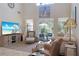 Bright living room features high ceilings, a large TV, and access to the outdoor patio and seating area at 5510 Siracusa Ln, Sanford, FL 32771