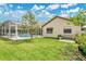 A lush backyard features a screened-in pool, seating area, and well-maintained green lawn at 5836 Goldenwood Dr, Orlando, FL 32817