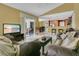 Open-concept living room with view into kitchen, dining room, and pool at 5836 Goldenwood Dr, Orlando, FL 32817
