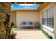 Cozy front patio featuring neutral tile, bench seating, and potted plants at 5836 Goldenwood Dr, Orlando, FL 32817