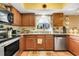 Efficient kitchen with warm wood cabinetry, stainless steel appliances, and granite countertops at 600 N Boundary Avenue # 119A, Deland, FL 32720