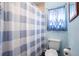 Standard bathroom features a toilet, shower with curtain, and window with natural light at 617 E Citrus St, Altamonte Springs, FL 32701