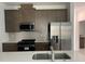 Modern kitchen featuring stainless steel appliances, gray backsplash, and quartz countertops at 6712 Golden Eagle Blvd, Howey In The Hills, FL 34737