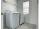 Convenient laundry room featuring washer, dryer, wire shelves, and tile flooring at 6712 Golden Eagle Blvd, Howey In The Hills, FL 34737