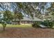 Backyard features a covered patio, green lawn, a small bridge and mature trees at 7237 Edmund Ct, Mount Dora, FL 32757