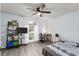 Bright bedroom featuring a ceiling fan, large window, and comfortable furnishings and hardwood floors at 7237 Edmund Ct, Mount Dora, FL 32757