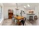 Dining room with long table, chandelier, and view of the kitchen with skylights at 7237 Edmund Ct, Mount Dora, FL 32757