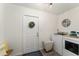 Convenient laundry room with white appliances, a round window, and stylish decor at 7237 Edmund Ct, Mount Dora, FL 32757