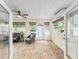 Bright sunroom featuring neutral furnishings, multiple windows, a ceiling fan, and tile floors at 7237 Edmund Ct, Mount Dora, FL 32757