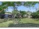 An open backyard with a privacy fence and mature trees partially shading the space at 7727 Arezzo Ave, Orlando, FL 32819
