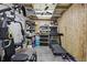 A basement area with exercise equipment, exposed ceiling, storage shelving, and wood paneling at 7727 Arezzo Ave, Orlando, FL 32819