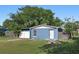 Charming blue one-story home featuring a well-maintained lawn and fenced-in yard at 7727 Arezzo Ave, Orlando, FL 32819