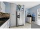 Open kitchen with white cabinets, stainless steel appliances, granite countertops, and an adjoining dining area at 7727 Arezzo Ave, Orlando, FL 32819