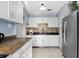 Well-lit kitchen with white cabinets, a mosaic backsplash and stainless steel appliances at 7727 Arezzo Ave, Orlando, FL 32819