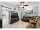 Inviting living room featuring tile floors, ceiling fan and a comfortable oversized brown sectional couch at 7727 Arezzo Ave, Orlando, FL 32819