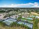 Aerial view featuring tennis courts, pool, bocce ball and clubhouse with tropical landscaping and ample parking at 7748 Four Seasons Blvd, Kissimmee, FL 34747
