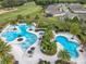 Breathtaking aerial view of the community pools, lush landscaping, and surrounding homes at 7748 Four Seasons Blvd, Kissimmee, FL 34747